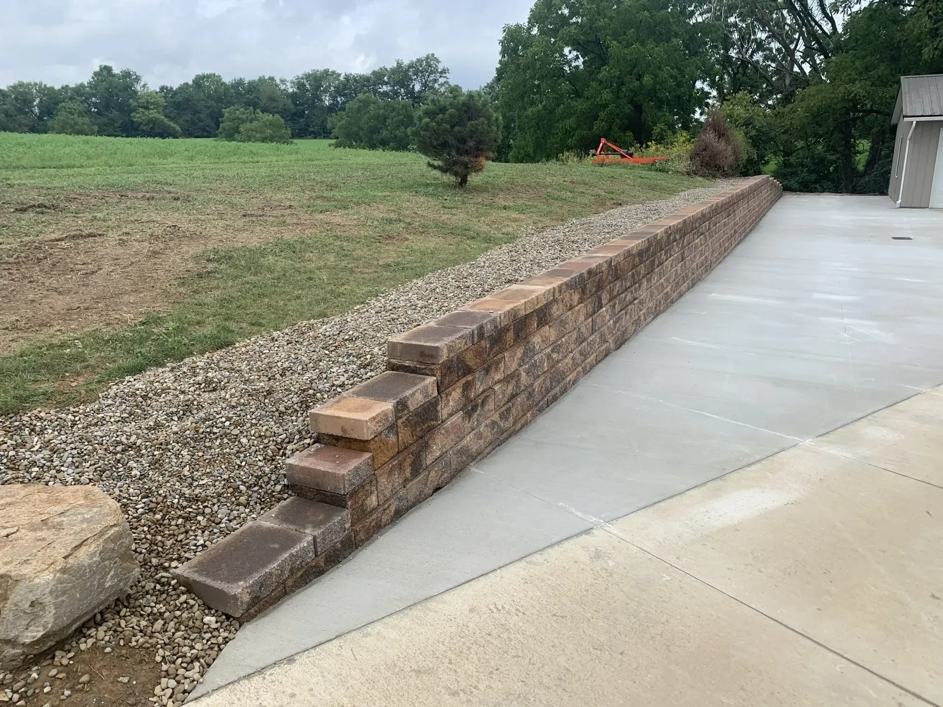 Segmental block retaining wall beside a concrete pad